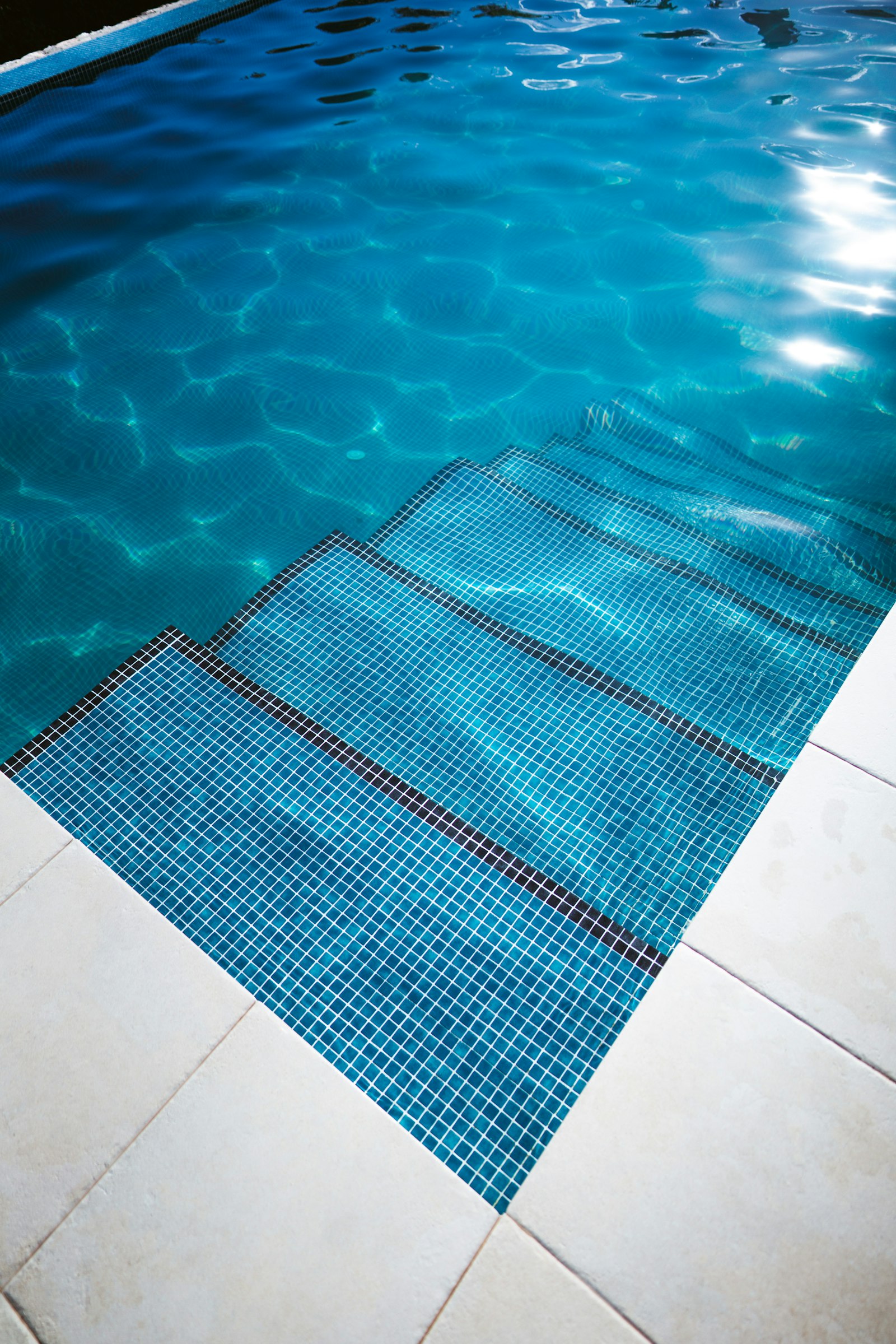 Piscina con suelo de azulejo blanco renovado